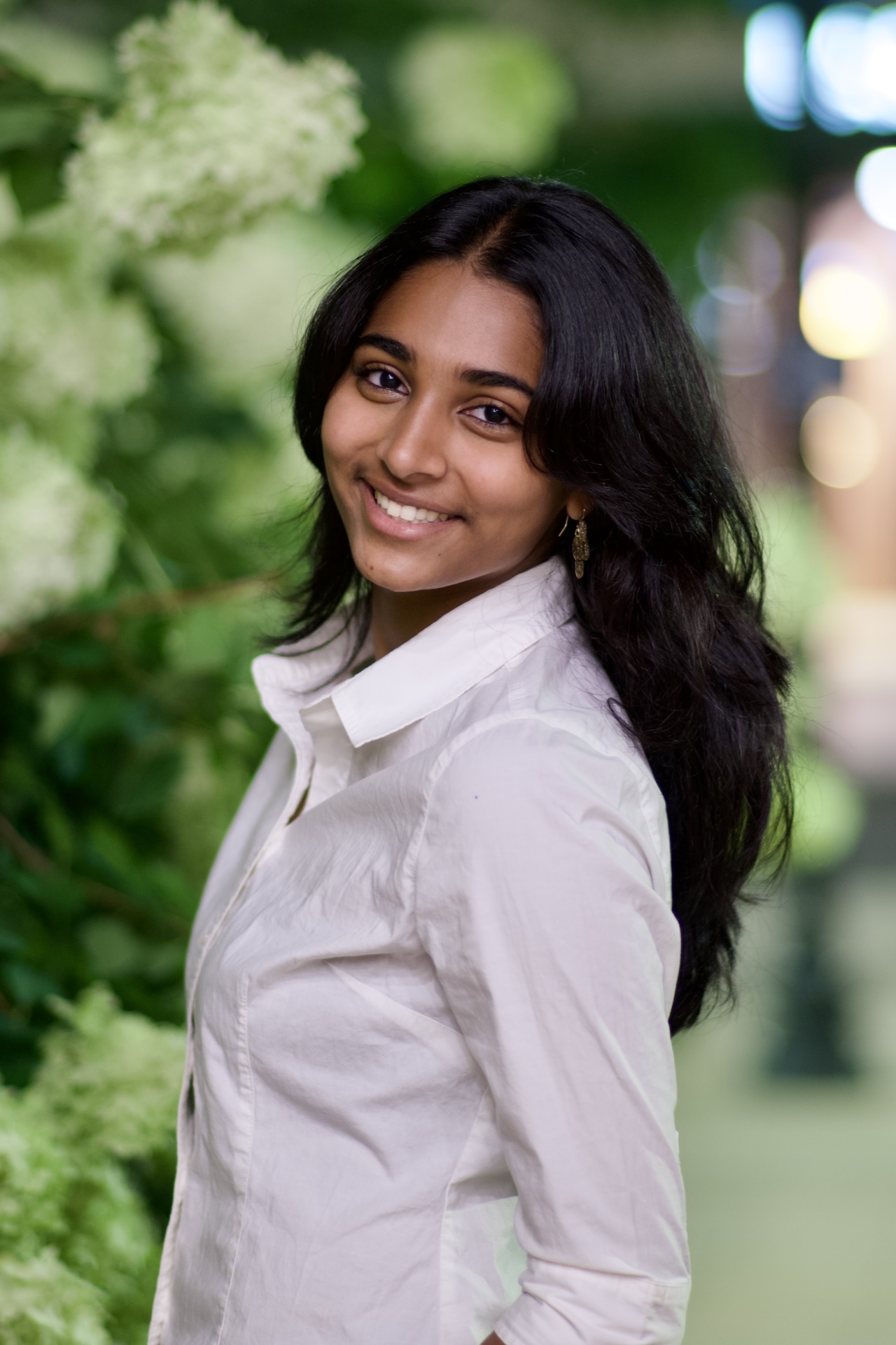Smiling natural-light portrait beside white hydrangeas at dusk — Vetri Frames, Northern Virginia