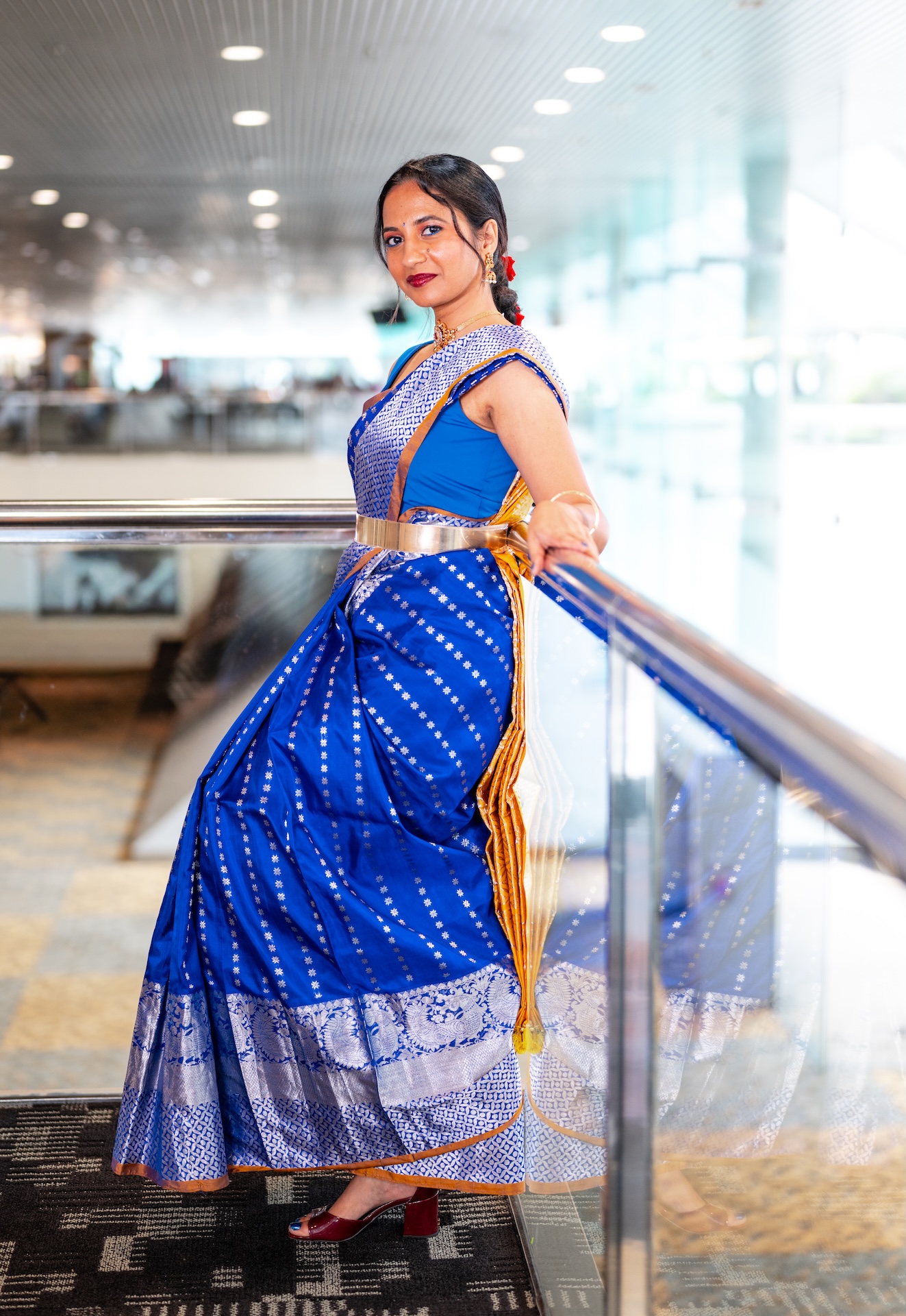 Royal blue silk saree with a gold belt beside a skywalk railing — Northern Virginia fashion