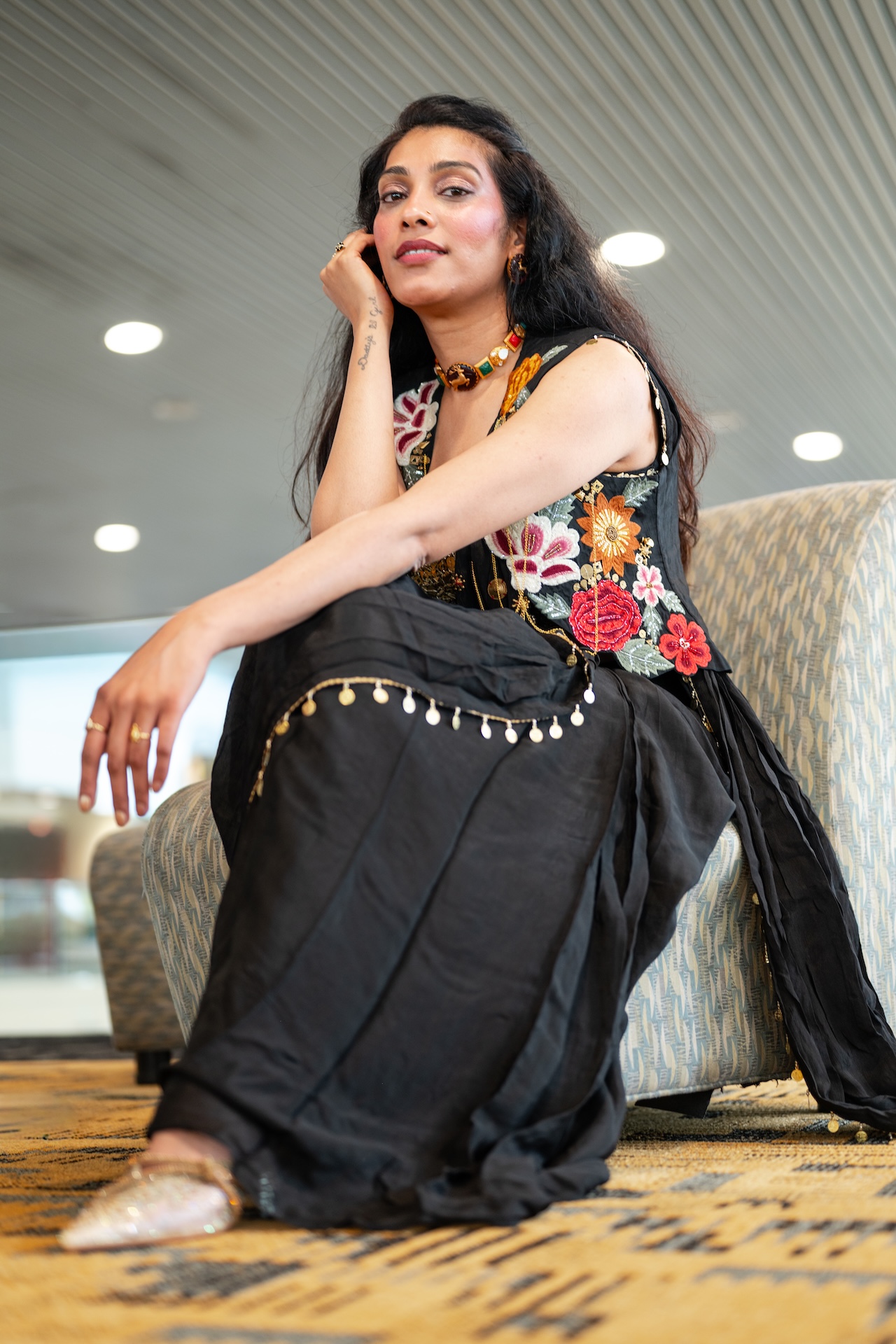 Seated low-angle portrait in a black floral corset saree — DMV editorial fashion photography