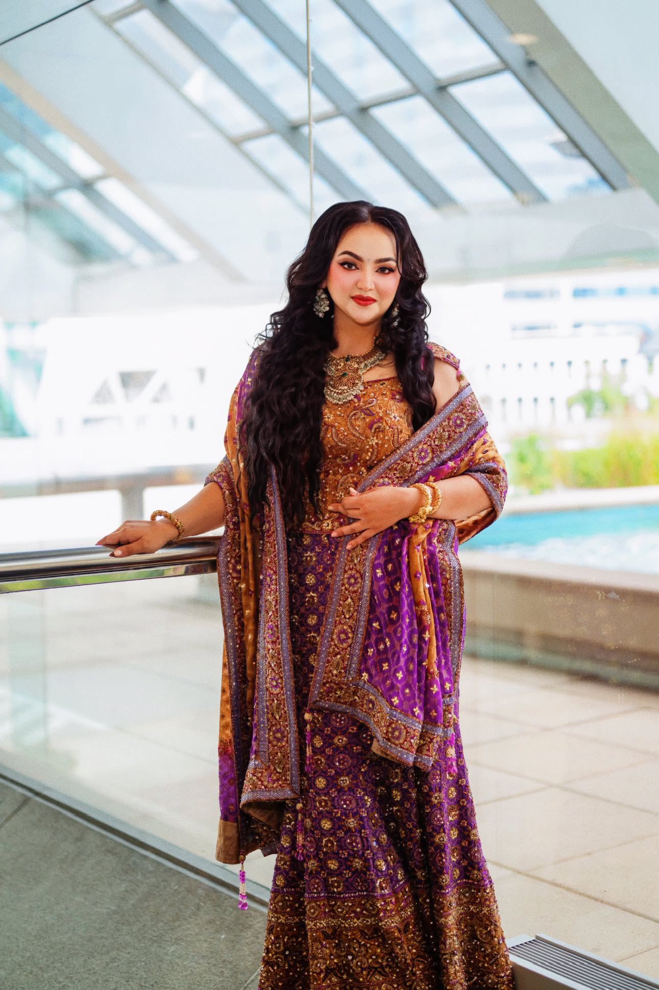 Full-length lehenga portrait beneath a glass atrium by the water — Northern Virginia fashion