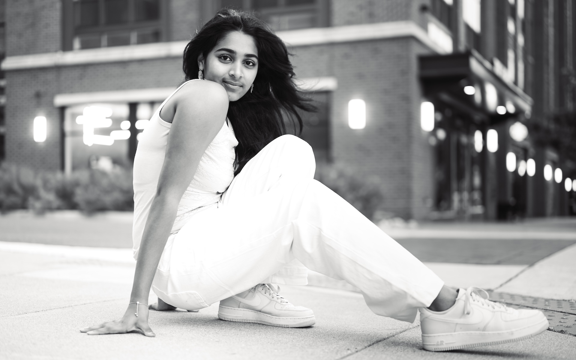 Black-and-white street portrait in white denim and sneakers on a city corner — VA & the DMV